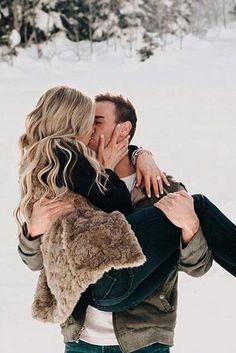 a man and woman kissing in the snow