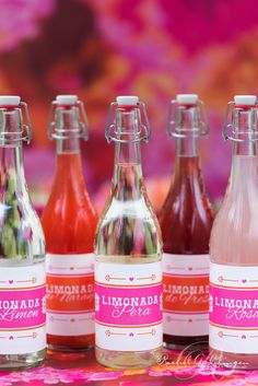 four bottles of liquid sitting on top of a table