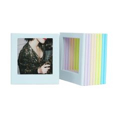 a white photo frame with multicolored sticks in it