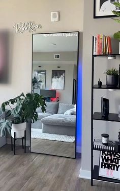 a mirror sitting on top of a wooden floor in a living room next to a couch