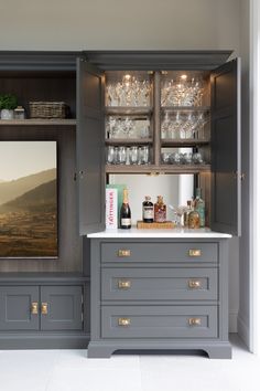 a kitchen with gray cabinets and white counter tops