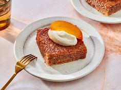 two white plates topped with slices of cake next to a glass of tea and a fork