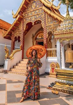 a woman standing in front of a building with an umbrella on it's head