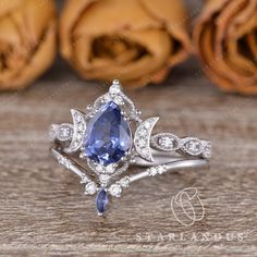 a blue and white ring sitting on top of a wooden table next to some roses