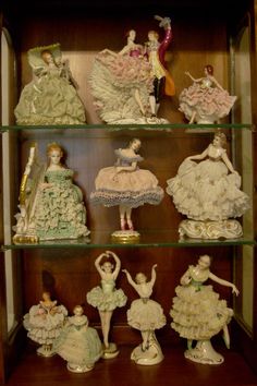 many figurines are displayed on glass shelves