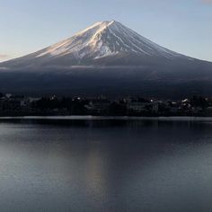 a large mountain towering over a city on top of a lake