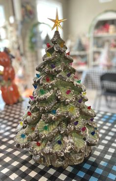 a small christmas tree sitting on top of a black and white checkered table cloth