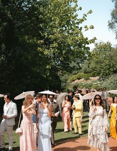 a group of people standing around each other holding umbrellas