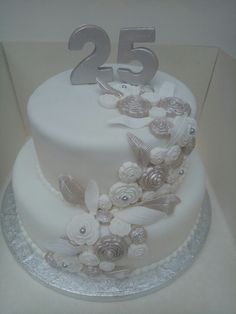 a white cake with silver numbers and flowers on it