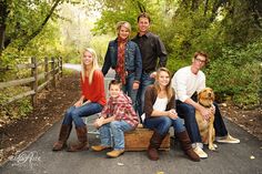 a group of people sitting on a wooden crate with a dog in front of them