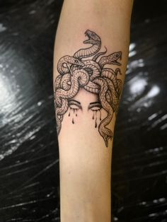 a woman's arm with a snake tattoo on it