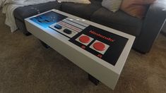 a living room with a couch, coffee table and rugs on the carpeted floor