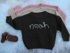 Adorable Toddler Sweater with Hand-Embroidered Name - Unique Colors in Pink, Beige, and Forest Green! ️ Description: ✨ Add a pop of personality to your little one's wardrobe with this charming hand-embroidered toddler sweater featuring their name in fun and colorful letters! Please note that the colors may differ slightly in person, making each sweater truly unique! 🌟 🌈 Product Details: 🧶 This cozy sweater is  100% soft and high-quality cotton, ensuring warmth and comfort for your toddler throughout the year. 🎨 Each name is meticulously hand-embroidered with vibrant thread, resulting in individual variations that make each sweater special. 🎨 Available in three delightful colors: Pink, Beige, and Forest Green, with unique color variations that add character to each sweater. 👶 Availabl Baby Name Sweater, Hand Embroidered Sweater, Name Sweater, Christmas Gift Baby, Lake Village, Personalized Sweater, Happy Parents, Toddler Sweater, Rose Beige