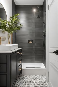 a modern bathroom with gray tile and white fixtures in the shower, tub, and sink