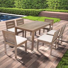 an outdoor table and chairs on a deck next to a swimming pool