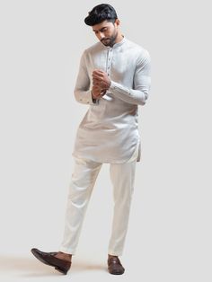 This Grey Pintucks Short Kurta Set will instantly give an elegant look. This 2 piece kurta set features a linen satin grey short kurta with pintuck details, front buttons fastening, and a mandarin collar. It is paired with narrow fitted pajama pants in cream color and malai cotton fabric. An ideal outfit for traditional occasions, and special events.  Size Chart For Men      	 	 					Size Chart For Men 		  		 		 						 				Size Chart For Men 				Description 			 			 				 				 				Sizes run small Short Kurta Set, Kurta Designs Men's, Satin Kurta, Short Kurta For Men, Kurta Pajama Men, Pyjama Pants