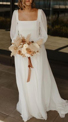 a woman in a white dress holding a bouquet