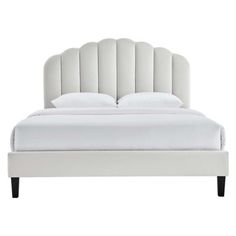 a white bed with an upholstered headboard