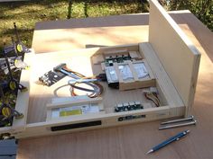 an electronic device is sitting on top of a wooden table with wires attached to it