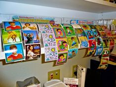 many children's pictures are hanging on the wall next to boxes and other items