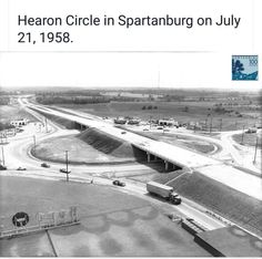 black and white photograph of an overpass with cars driving on the road in front of it