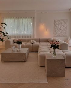 a living room filled with lots of furniture and flowers in vases on the coffee table