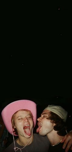 two young men wearing pink hats with their mouths open