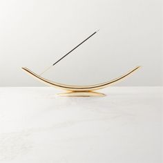 a pair of scissors sitting on top of a wooden stand next to a white wall