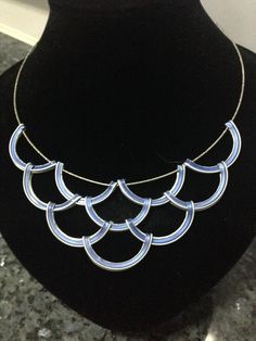 a necklace is shown on a mannequin with black and white marbled surface