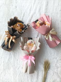 three small boxes with teddy bears in them sitting on a white surface next to each other