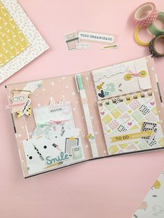 an open planner book sitting on top of a pink table