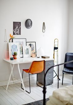 an image of a room with pictures on the wall and furniture in it, including a desk