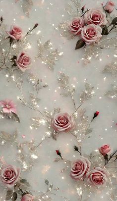 some pink roses and silver leaves on a white background with sparkles in the air