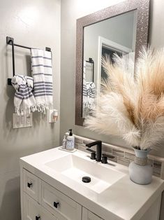 a bathroom with a sink, mirror and towel rack