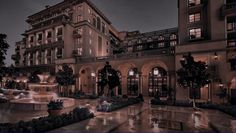 a large building with many windows and lights on it's sides at night time