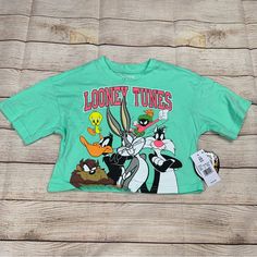 Looney Tunes Girls Size Xs Looney Tunes Characters Green Cropped T-Shirt. Show Off Your Love For The Looney Tunes Gang With This Green Cropped T-Shirt! Made From A Comfortable Blend Of 40% Polyester And 60% Cotton, This Shirt Features Your Favorite Characters And Is Perfect For Any Fan. The Short Sleeves And Crew Neckline Give It A Classic Look, While The Machine-Washable Fabric Ensures Easy Care. This Looney Tunes T-Shirt Is Brand New With Tags And Perfect For Girls In Size Xs. It's Ideal For W Fun Character Print Tops For Spring, Green Tops With Character Print For Spring, Cute Green Top With Cartoon Print, Green Graphic Tee With Character Print, Looney Tunes Characters, Cropped T Shirt, Crop Tshirt, Looney Tunes, Classic Looks