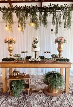 the table is covered with greenery and gold vases