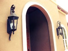 an entrance to a house with a lamp on the wall