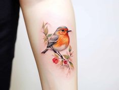 a small bird sitting on top of a branch with leaves and berries around its neck