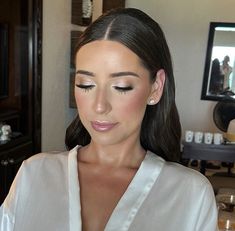 a woman with long dark hair wearing a white shirt