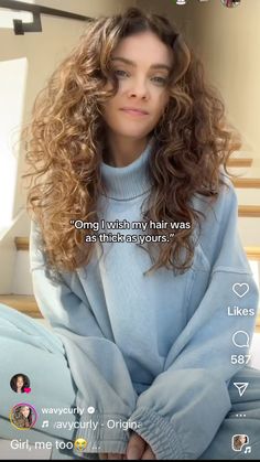 a woman with long curly hair sitting down