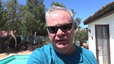 an older man wearing sunglasses standing in front of a pool