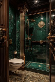 a fancy bathroom with green marble walls and flooring, along with a walk in shower