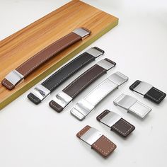 several different types of leather watch bands on a wooden box with a cutting board in the background