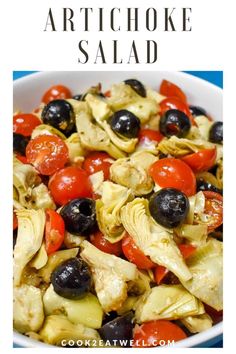 artichoke salad in a white bowl with olives and tomatoes