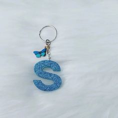 the letter s is made out of glitter and has a blue butterfly on it's back