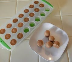 an egg tray with several eggs in it next to a white plate on the floor