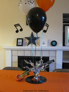 an orange table topped with balloons and streamers