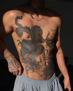 a shirtless man with tattoos on his chest