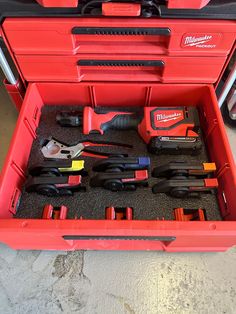 a red toolbox filled with tools on the floor